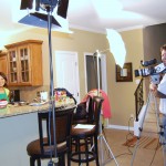 tran shooting a commercial for hormel foods while her kids watch from the stairs.