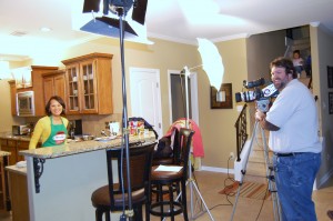 tran shooting a commercial for hormel foods while her kids watch from the stairs.